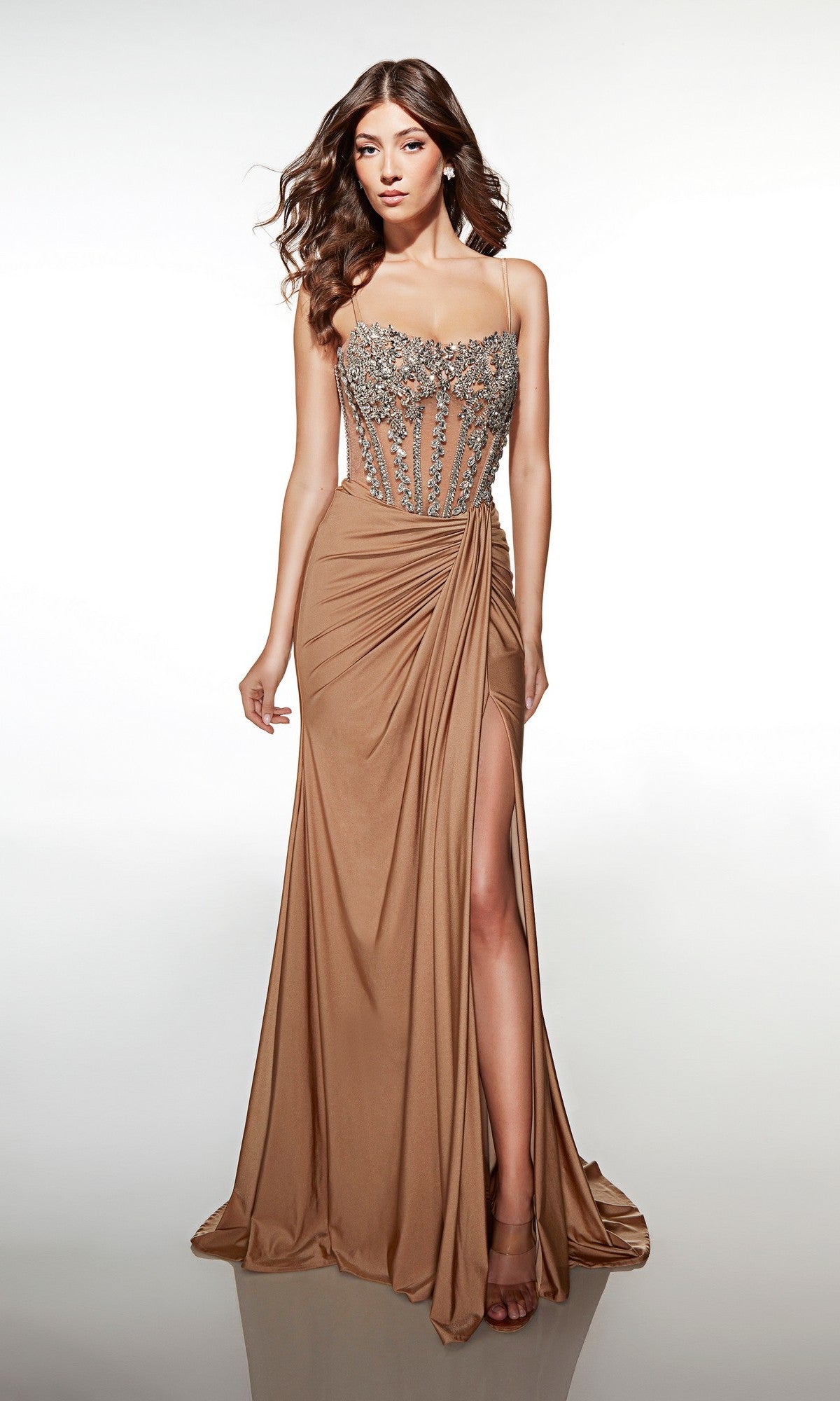 A woman wears the Alyce 62123 long prom dress—tan, sleeveless, with a beaded corset bodice and high-leg slit—standing against a plain white background.